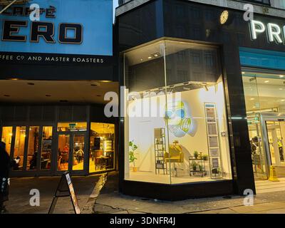 Manchester, Großbritannien - 22. Januar 2026: Nachtszene in Manchester mit Café Nero Storefront und heller Fensterfront. Stockfoto