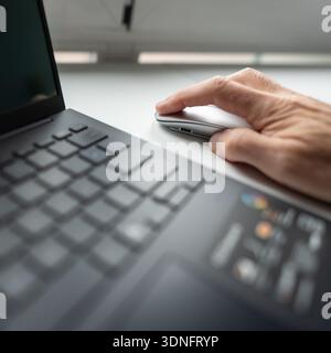 Die Hand des Mannes drückt die linke Maustaste auf einem sehr nahen Foto. Stockfoto