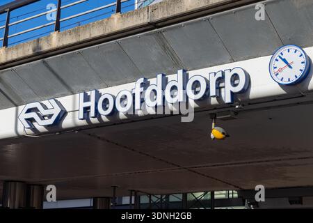 Nahaufnahme des Bahnhofseingangsschildes Hoofddorp mit dem niederländischen NS-Logo und einer Bahnhofsuhr, die die Infrastruktur des öffentlichen Nahverkehrs zeigt. Hoofddorp Stockfoto
