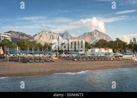 Eine wunderschöne Strandlandschaft mit einem Resort-Hotel in der Kemer-Region in der Türkei. Ein sonniger Morgen mit dem Taurusgebirge am Horizont. Stockfoto