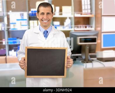 Porträt eines Apothekers, der in seinem Laden steht und lächelt mit Tafel Stockfoto