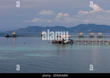 Blick auf die Docks und Tiki-Hütten auf der Insel Seraja Kecil, auch bekannt als Seraya, vor der Küste von Labuan Bajo, Indonesien. Stockfoto