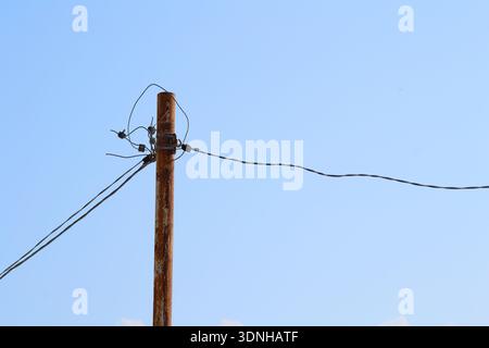 Alter rostiger Elektromast mit Drähten Stockfoto
