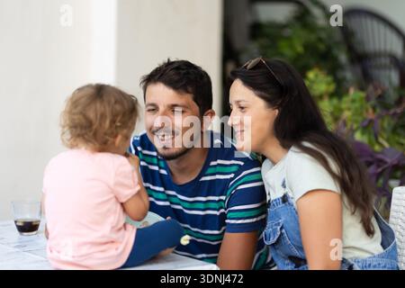 Glückliche Familie, die einen Moment zusammen genießt, Eltern, die liebevoll mit ihrem Kind im Freien interagieren Stockfoto