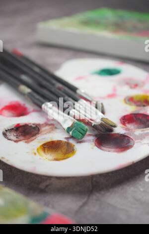 Mischen von Farben mit Pinseln auf einer Palette Stockfoto