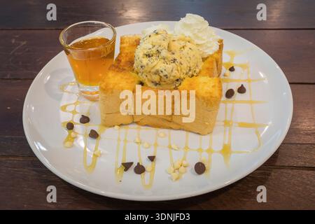 Honigtoast auf weißem Geschirr. Garniert mit Schlagsahne und Eis. Süßes Dessert. Stockfoto