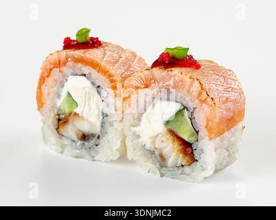 Eine Nahaufnahme von zwei japanischen Uramaki-Sushi-Brötchen mit gebratenem Lachs, Aal, Frischkäse, Gurke. Garniert mit rotem Tobiko-Reh. Saubere, minimalistische Komposition Stockfoto