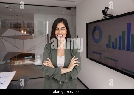 Porträt einer Geschäftsfrau, die allein im modernen Tagungsraum posiert Stockfoto