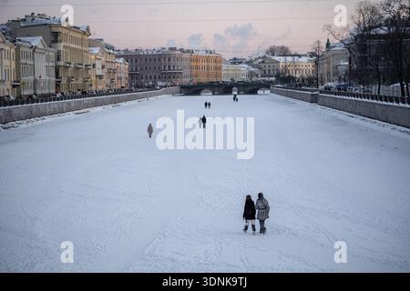 Menschen, die an kalten Wintertagen auf gefrorenen Flüssen und Kanälen in St. Petersburg, Russland, spazieren gehen. Stockfoto