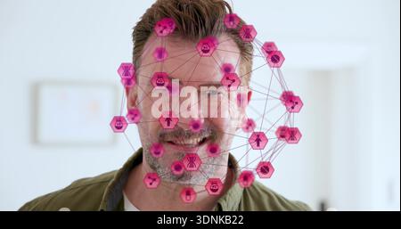 Er zeigt einen Reifen Mann mit olivgrünem Hemd in einem hellen Home Office und zeigt eine magentafarbene AR-Überlagerung Stockfoto