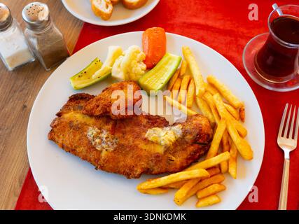 Gebratenes paniertes Fischfilet mit pommes frites und eingelegtem Gemüse Stockfoto