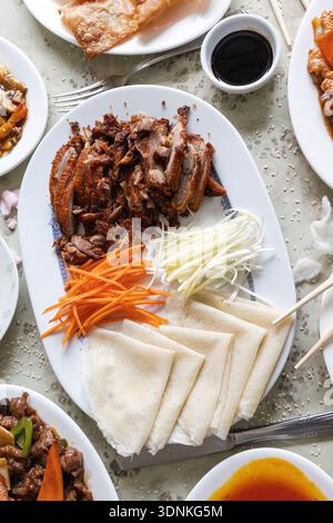 Knusprige peking-Ente mit geriebenen Zwiebeln, Karotten und Pfannkuchen bereit zum Einpacken Stockfoto