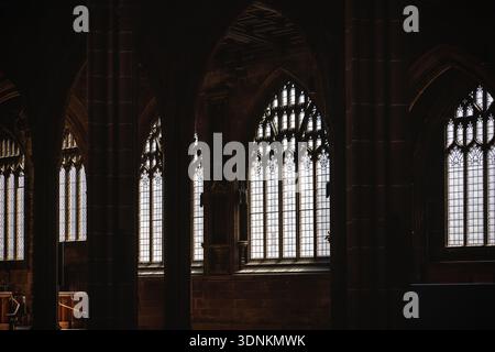 Innenansicht einer historischen gotischen Kathedrale mit großen Bogenfenstern und ornamentaler Steinarchitektur. Sanftes Tageslicht tritt durch das gemusterte G ein Stockfoto