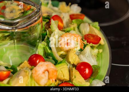 Nahaufnahme von Salat mit Gemüse und gebratenen Garnelen auf einem festlichen Tisch Stockfoto