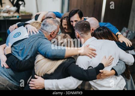 Verschiedene Gruppen von Kollegen und Freunden nehmen sich in einem engen Teamwork-Moment der Einheit ein Stockfoto