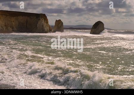 Dramatische Wellen treffen bei stürmischem Wetter auf die Kalksteinen und Klippen in der Freshwater Bay auf der Isle of Wight, England, Großbritannien. Stockfoto