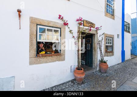 Historische ummauerte Stadt Óbidos, Portugal, mit mittelalterlichen Mauern, Kopfsteinpflasterstraßen, weiß getünchten Häusern und einer Burg auf einem Hügel in einem malerischen Porrugal Stockfoto