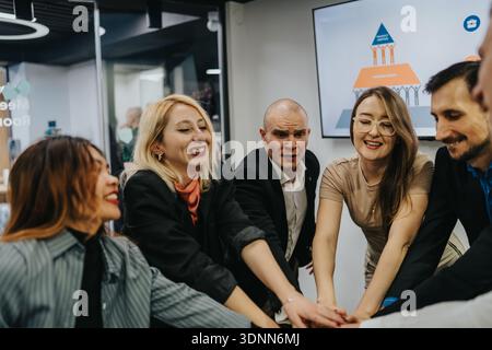 Eine vielfältige Gruppe von Fachleuten vereint sich in einer modernen Szene für die Zusammenarbeit im Büro Stockfoto