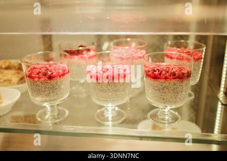 Chia Samenpudding in Glasbechern mit Himbeerauflage in einem Café. Gesundes Dessertkonzept, modernes Café-Menü, frische Süßigkeiten Stockfoto