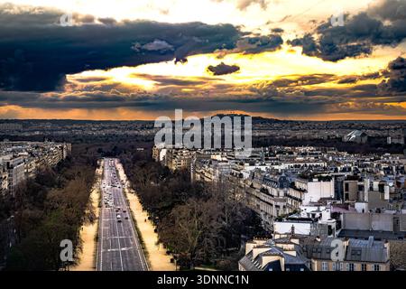 Sonnenuntergang über Paris: Blick vom Arc de Triomphe auf die Avenue de la Grande Armée unter einem dramatischen Himmel Stockfoto