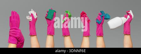 Reinigungswerkzeuge in der Hand mit rosa Schutzhandschuhen gegen Grau. Verschiedene Werkzeuge, einschließlich Schwamm, Tuch, Wischtücher und Sprühflasche. Konzept von prof Stockfoto