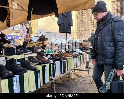 Schuhmarkt am Mercato Porta Nolana, Neapel, Italien. Shopper stöbern in Freizeitschuhen, die draußen auf Boxen ausgestellt sind. Neapel Street Commerce. Stockfoto