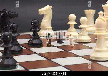 Miniaturfiguren auf einem Brett, die den entscheidenden Schritt im Leben veranschaulichen Stockfoto