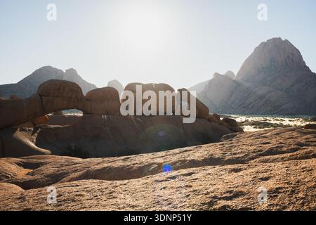 Sonnenverwöhnte Felsformationen in Spitzkoppe in Namibia, die die raue Schönheit der zerklüfteten Landschaften und einzigartige geologische Besonderheiten unter einem hellen Kessel zeigen Stockfoto