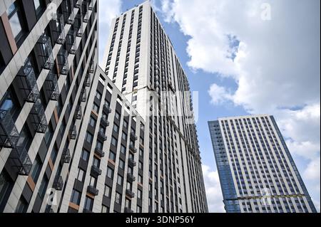 Blick auf moderne Hochhäuser im Bau, mit zeitgenössischer Architektur und Baumaterialien gegen teilweise cl Stockfoto