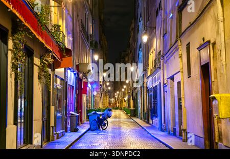 Rue Saint-Sauveur im 2. Bezirk von Paris Frankreich. Die historische, enge Kopfsteinpflasterstraße bietet abends beleuchtete Geschäfte und Cafés Stockfoto