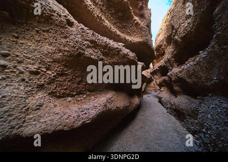 Schmaler Pfad durch die rauen Wände des Slot Canyon mit dramatischem natürlichem Licht Stockfoto