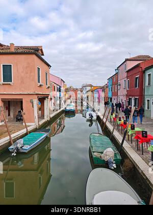 Kanal gesäumt von bunten Häusern und kleinen Booten in Burano in der Nähe von Venedig, Italien, Februar 2026. Stockfoto