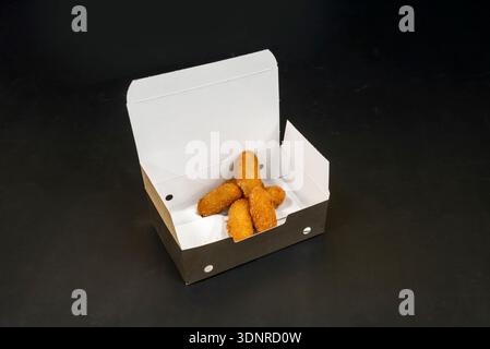 Ein Tablett mit kleinen Mini-Kroketten in verschiedenen Geschmacksrichtungen, jedes mit einem Zahnstocher für einfaches Pflücken auf einer Party. Stockfoto