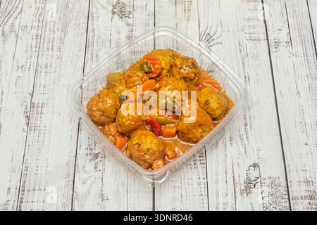 Fleischbällchen und Fischfleischbällchen zusammen in einer gelblichen Safran- oder Currysauce, serviert in einer tiefen Schüssel für eine zwanglose Mahlzeit Stockfoto