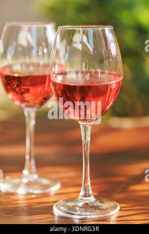 Rosenweingläser auf dem sonnigen Tisch Stockfoto