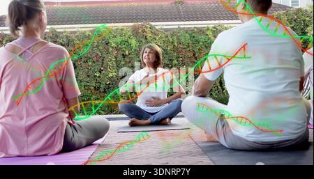 Leitender Oberlehrer mit weißem T-Stück, das das Atmen auf der Terrasse mit Yogamatten und DNA-Überlagerung führt Stockfoto