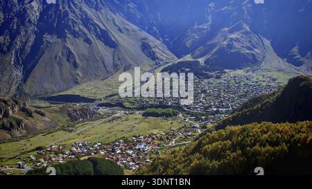 Stadt eingebettet in ein Tal mit umliegenden Bergen, klare Aussicht, Stepantsminda, Kaukasus, Georgien Stockfoto