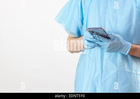 Medizinische Mitarbeiterin in Scrubs Holding Phone, Krankenhaus-Kommunikationskonzept Stockfoto