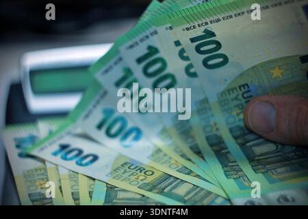 Nahaufnahme der Hände eines unbekannten kaukasischen älteren Mannes, der 100-Euro-Banknoten hält und zählt, Geldvermögenversicherungszahlungen oder lebenslange Sparungen Copy spac Stockfoto