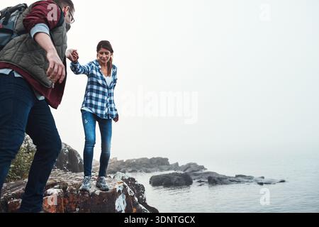 Paare, Wandern oder Hände auf Bergfelsen halten für Outdoor-Abenteuer, Reisen oder Reisen. Mann, Frau oder Wanderer, die mit Platz für Trekking helfen Stockfoto