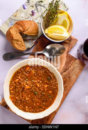 Traditionelle griechische Linsensuppe, serviert in einem rustikalen Restaurant mit Olivenöl, Kräutern und mediterranem Tischstil. Stockfoto