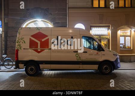 Krakau, Polen - 30. November 2025: Weißer DPD-Lieferwagen parkt nachts auf einer kopfsteingepflasterten europäischen Stadtstraße, bereit für schnelle Paketversand Stockfoto