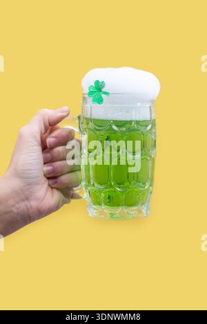 Grüner Bierkrug mit Schaum für St. Patrick’s Day auf gelbem Hintergrund Stockfoto