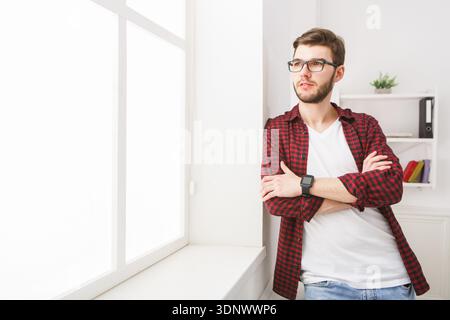 Selbstbewusster junger Geschäftsmann im Büro nahe Fenster Stockfoto