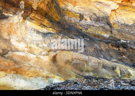 Dieses Bild zeigt eine lebendige geologische Formation am Bergbaustrand Asturiens. Verschiedene Schichten und farbenfrohe Mineralienablagerungen weisen auf den Reichtum der Region hin Stockfoto