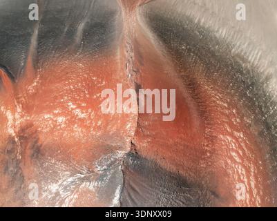 Aus der Vogelperspektive leuchtende rote und schwarze Texturen auf dem Vulkan Jote in Catamarca, Argentinien, mit komplexen Mustern und natürlicher abstrakter Schönheit Stockfoto