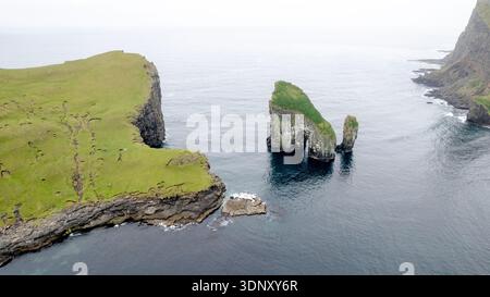 Ein atemberaubender Blick aus der Vogelperspektive auf die zerklüfteten Klippen und Meeresberge auf der Insel Vagar auf den Färöern, die die natürliche Schönheit und das dramatische lan zeigen Stockfoto