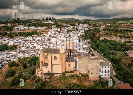 Historische Hügellandschaft mit weißen Häusern und Einer prominenten Kirche in Einem grünen Valleyscape, Setenil de las Bodegas, Spanien Stockfoto