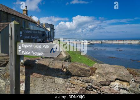 Seahouses Harbour. Blauer Himmel und Sonnenschein. Küstenpfad Wegweiser Walkers. Seahouses ist ein beliebtes Fischerdorf am Meer in Northumberland. UK Stockfoto
