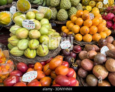 FUNCHAL, MADEIRA, PORTUGAL - 2. FEBRUAR 2026: Nahaufnahme von lebhaften tropischen Obstsorten auf dem Marktstand in Funchal, Madeira Stockfoto